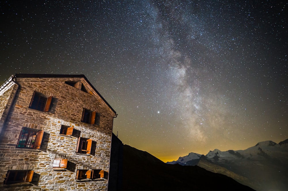 brown brick house under starry night