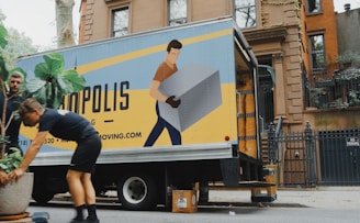 woman in blue shorts and black boots standing beside yellow and white truck during daytime