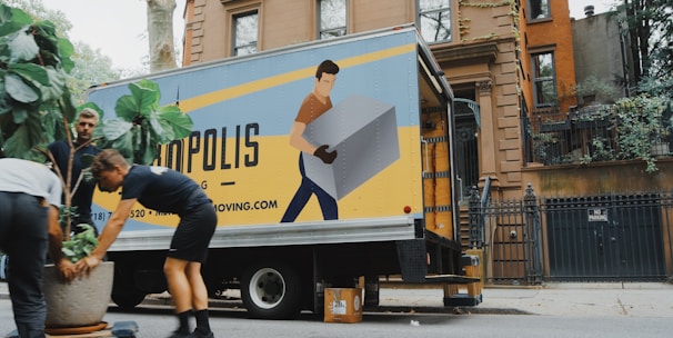 woman in blue shorts and black boots standing beside yellow and white truck during daytime