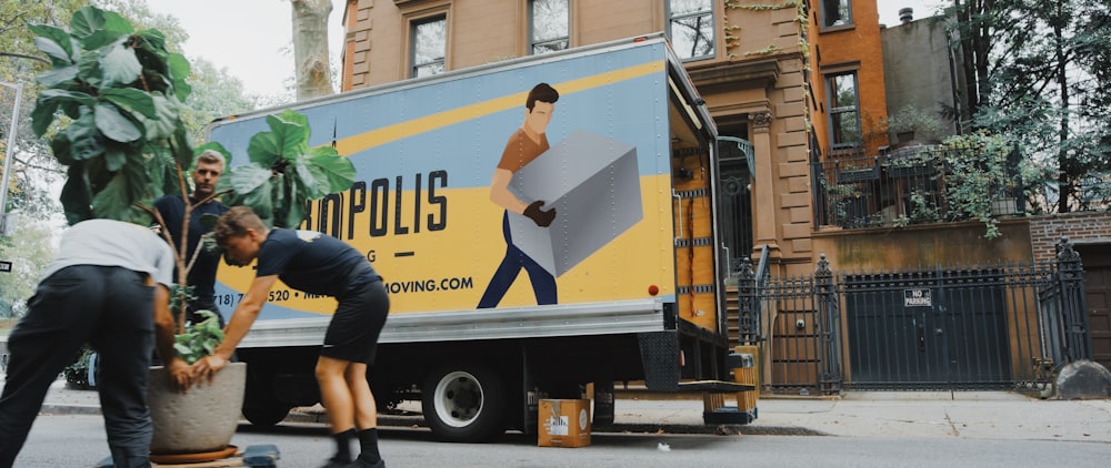 Moving truck with people moving a plant