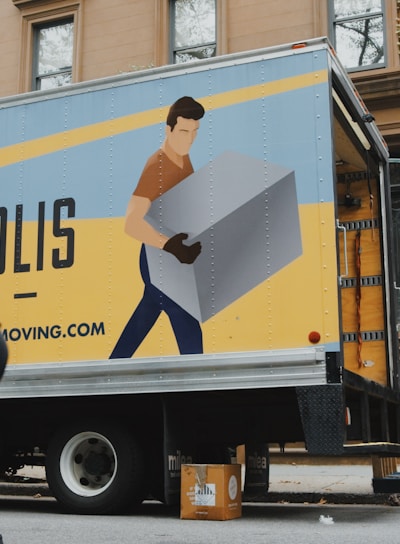 woman in blue shorts and black boots standing beside yellow and white truck during daytime