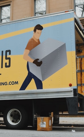 woman in blue shorts and black boots standing beside yellow and white truck during daytime