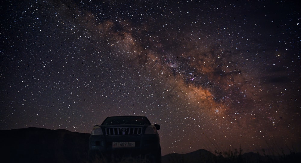 black jeep wrangler on snow covered ground under starry night