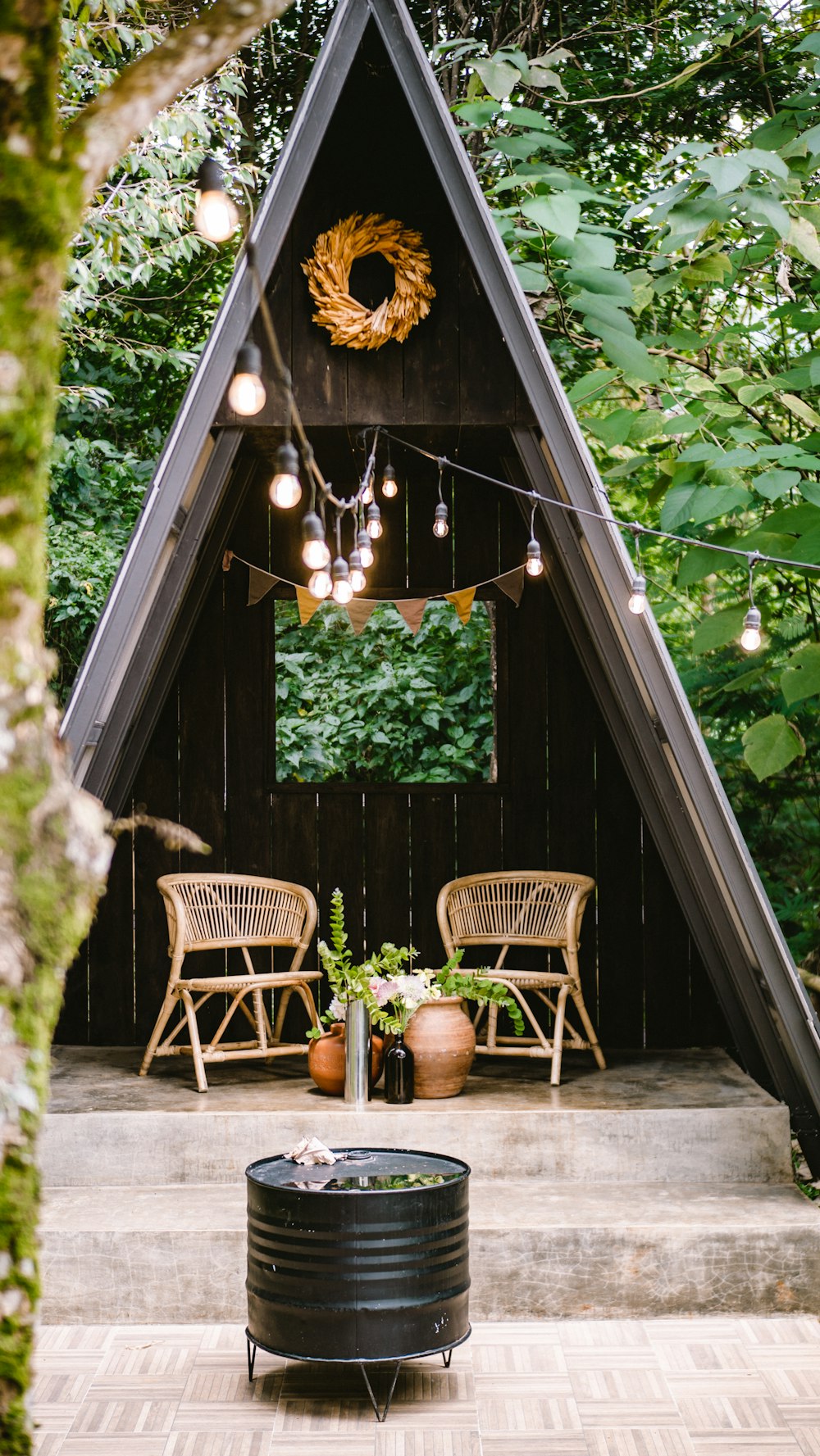 brown wooden chairs and table near green trees during daytime