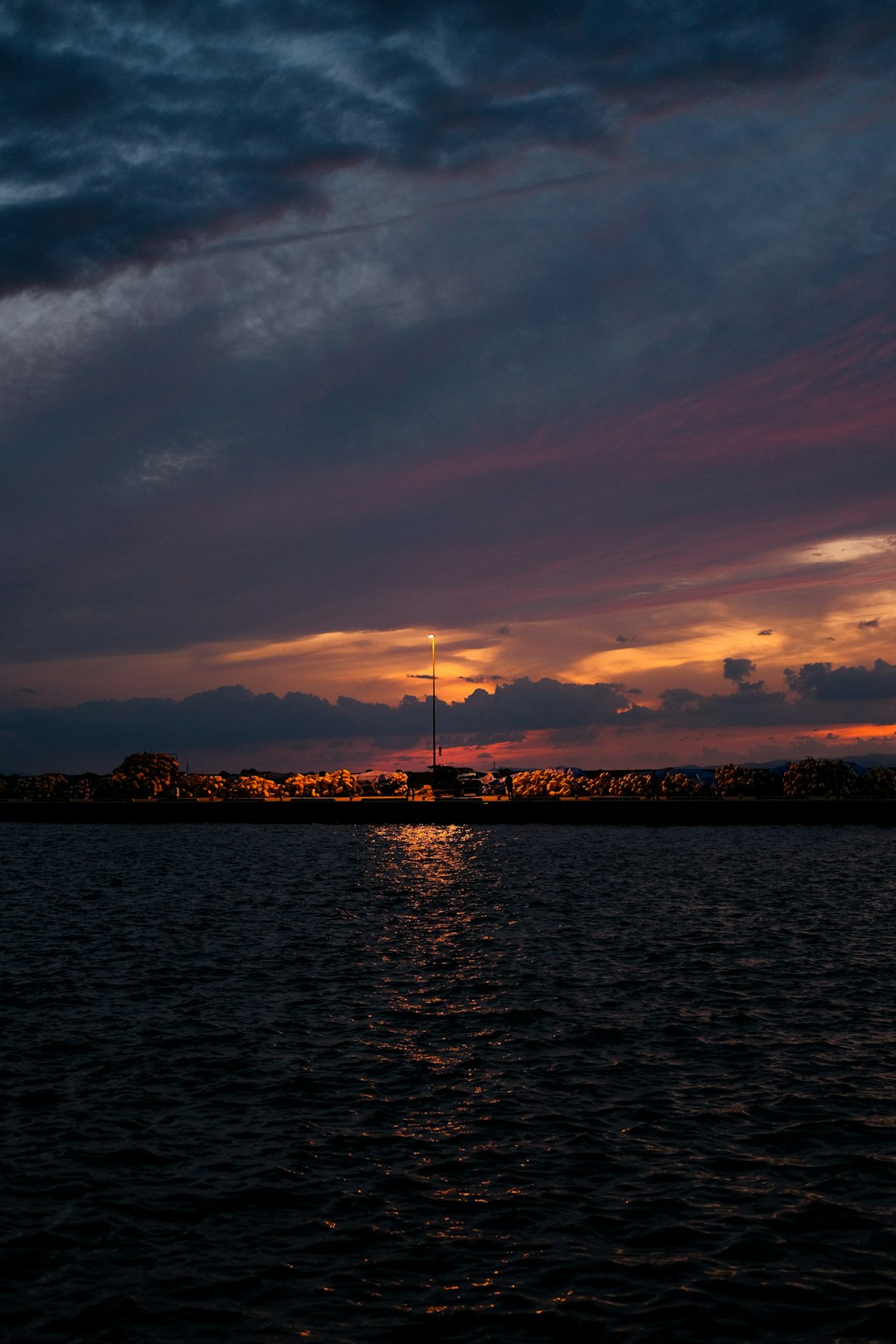 body of water near city buildings during sunset