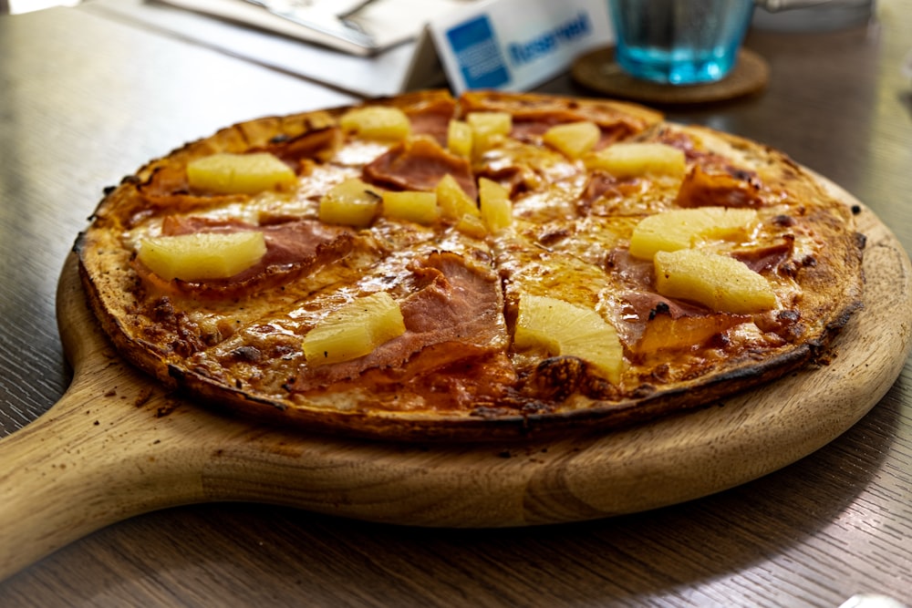 pizza on brown wooden round tray