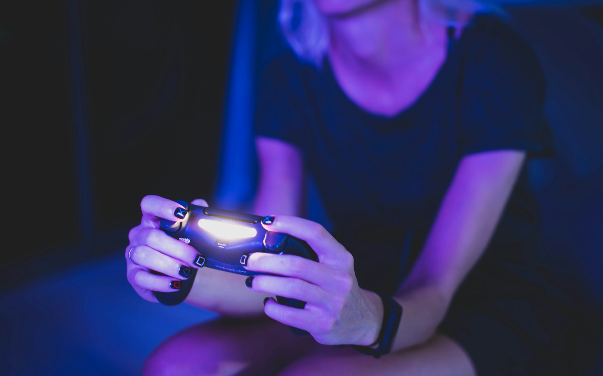 A dynamic shot of a girl gamer in pinup style, illuminated by neon lights, intensely focused on her game controller.