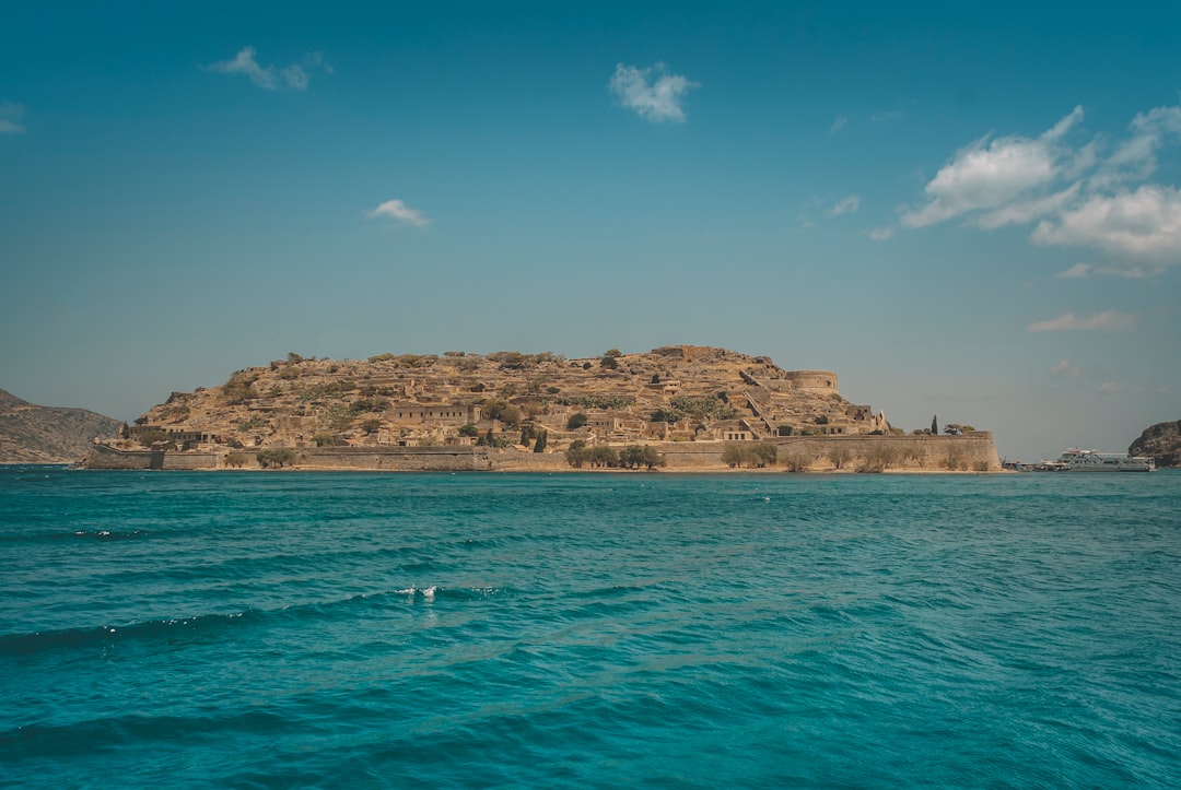 brown rock formation on sea under blue sky during daytime