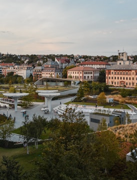 A panoramic view of a lively urban park surrounded by renovated buildings.