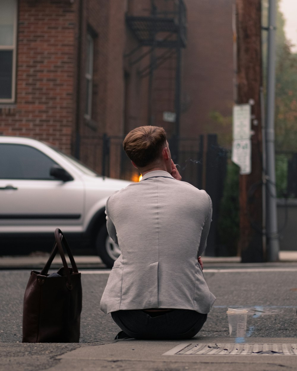 woman in gray long sleeve shirt and black pants carrying black leather bag