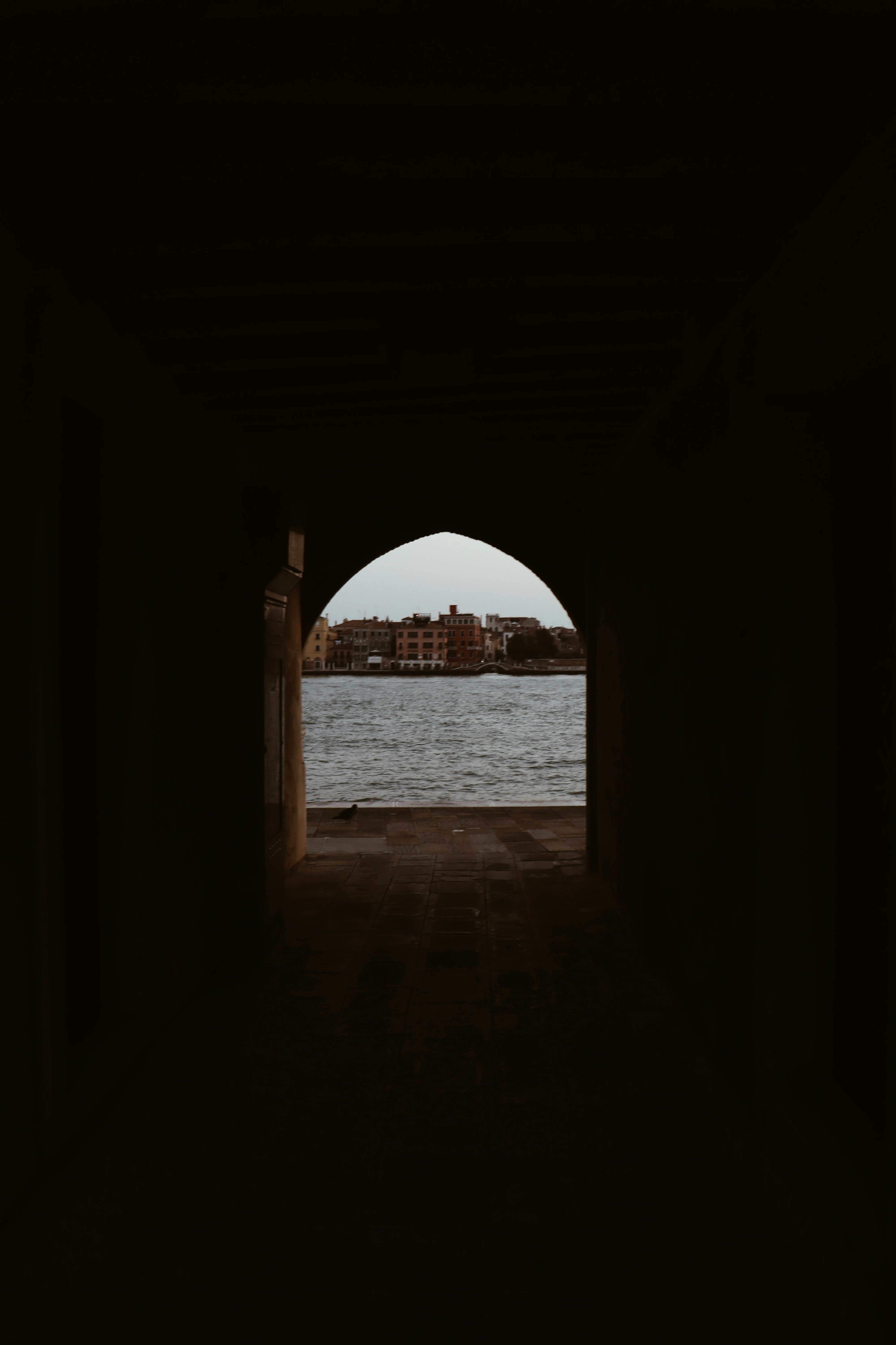 brown concrete arch near body of water during daytime