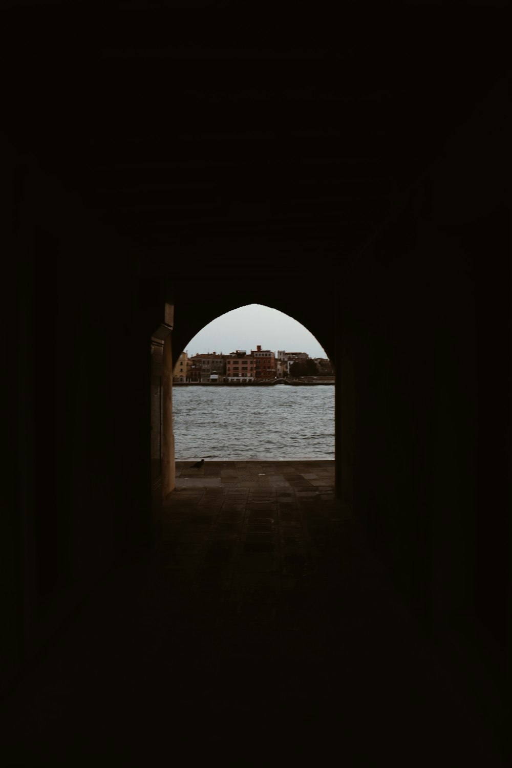 brown concrete arch near body of water during daytime