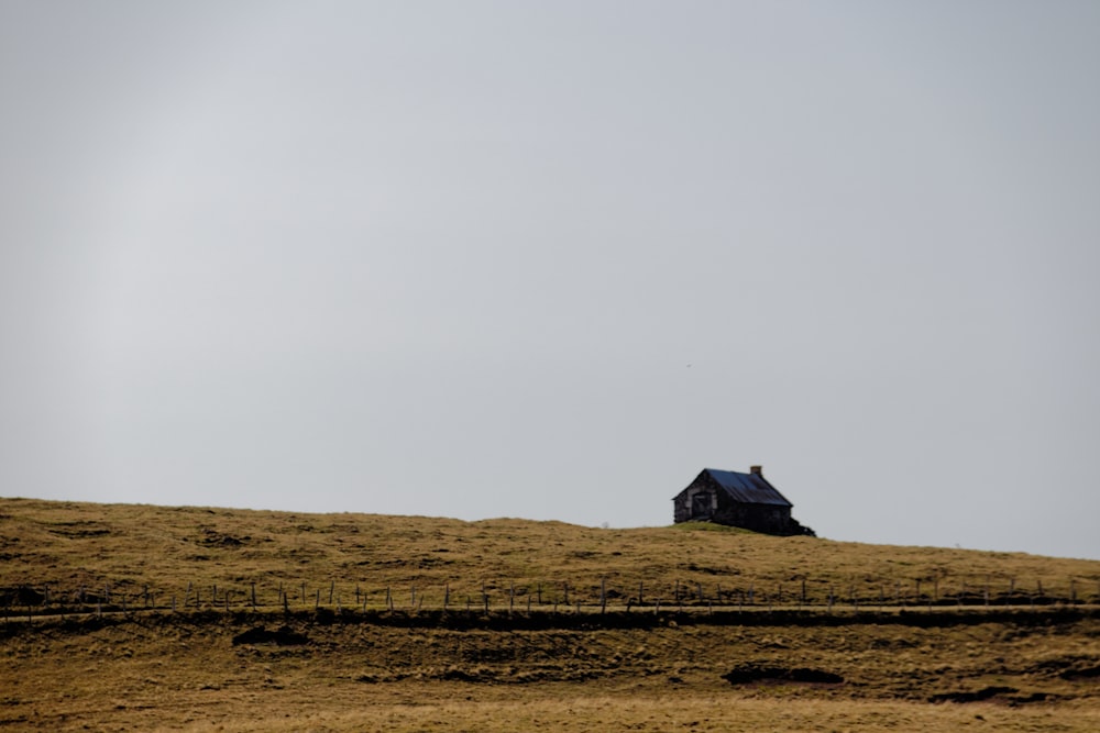 brown wooden house on brown field under white sky during daytime