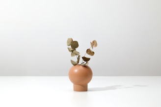 A modern minimalist floral arrangement with mint and eucalyptus green tones on a wooden table