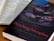An open book with text is positioned next to another book titled 'Preaching Metaphor: How to shape sermons that shape people' by Justin Rossow. The cover features an image of hands shaping clay on a pottery wheel.