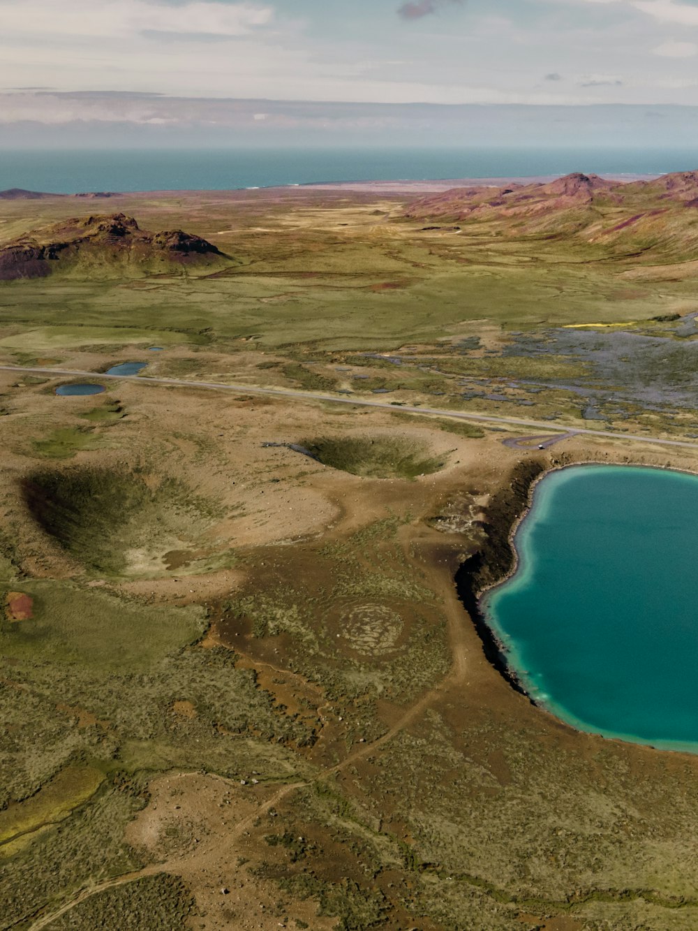 aerial view of green grass field near blue sea during daytime