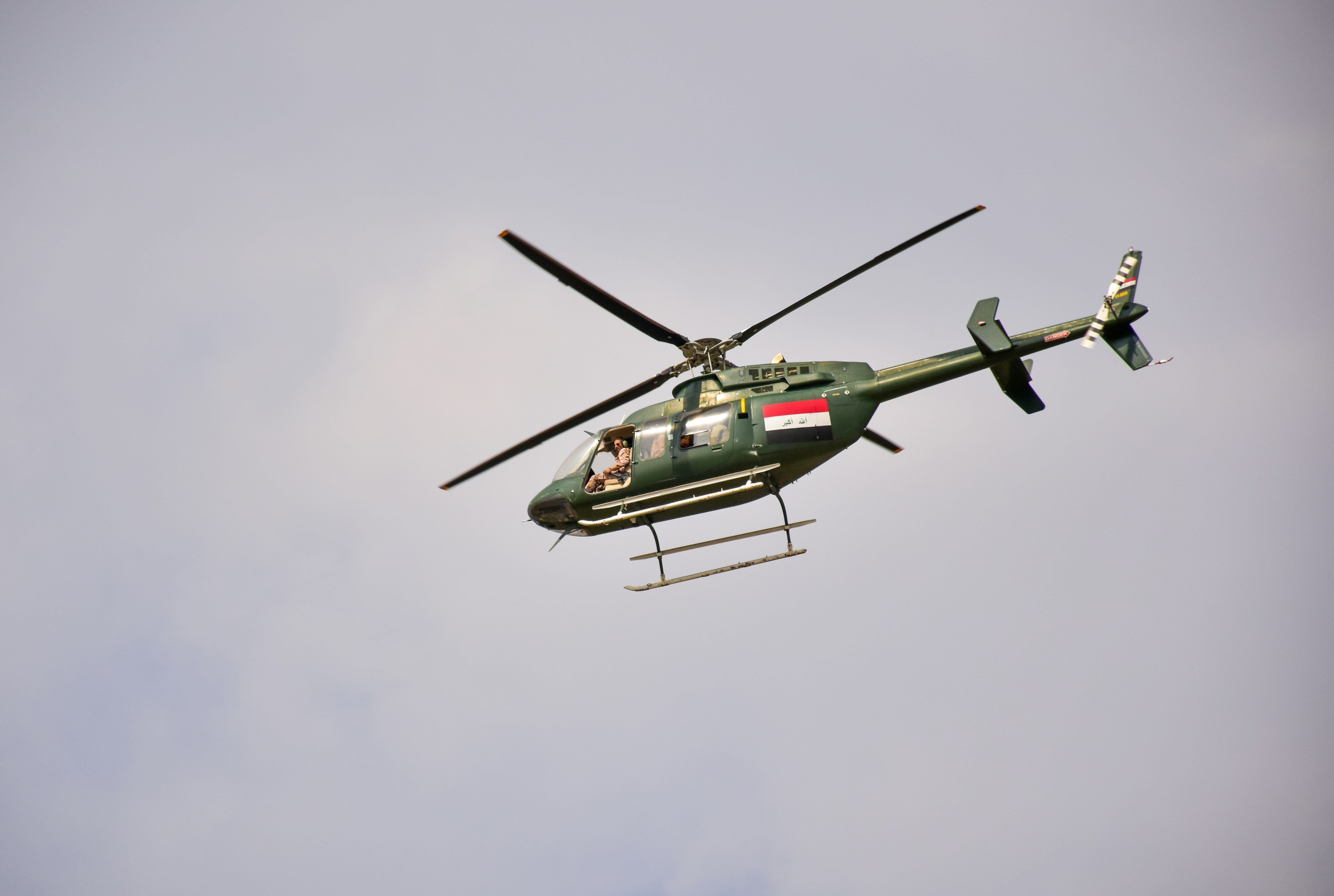 green and black helicopter flying in the sky, 