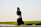 woman in white long sleeve shirt and black hijab standing on brown field during daytime