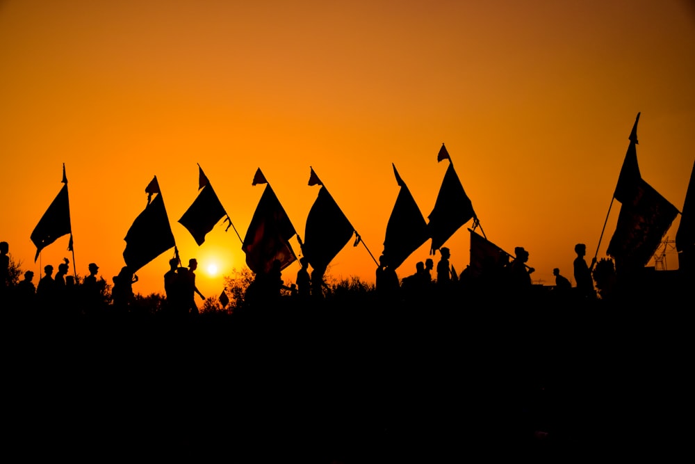Silueta de la gente en el campo durante la puesta del sol