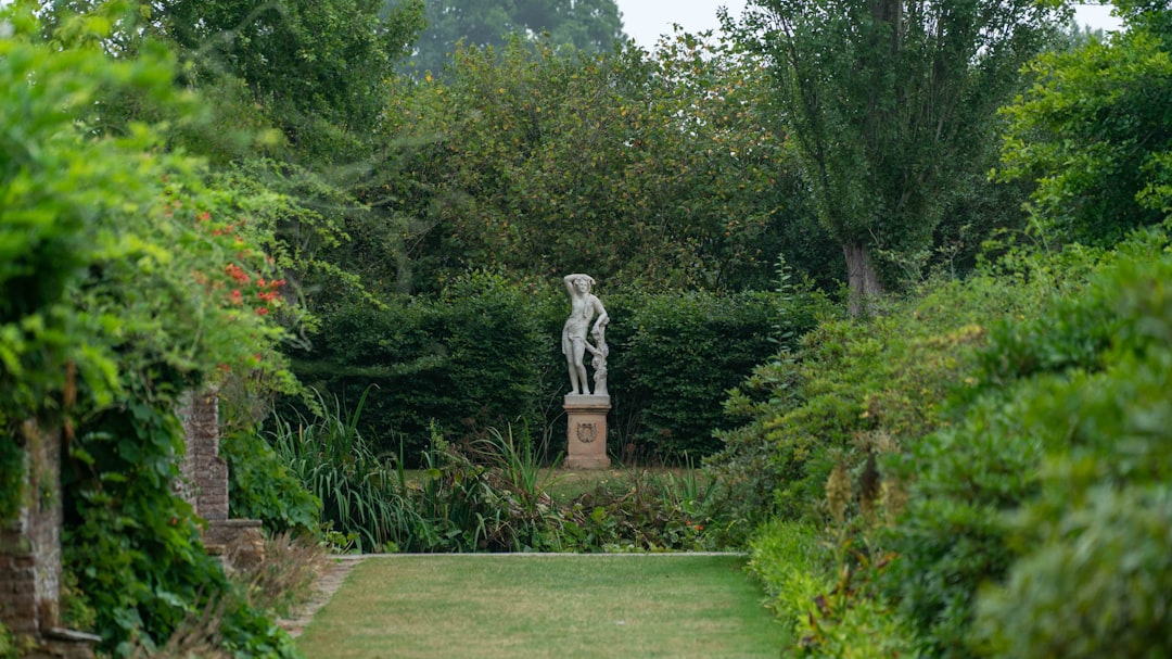 gray concrete statue near green trees during daytime