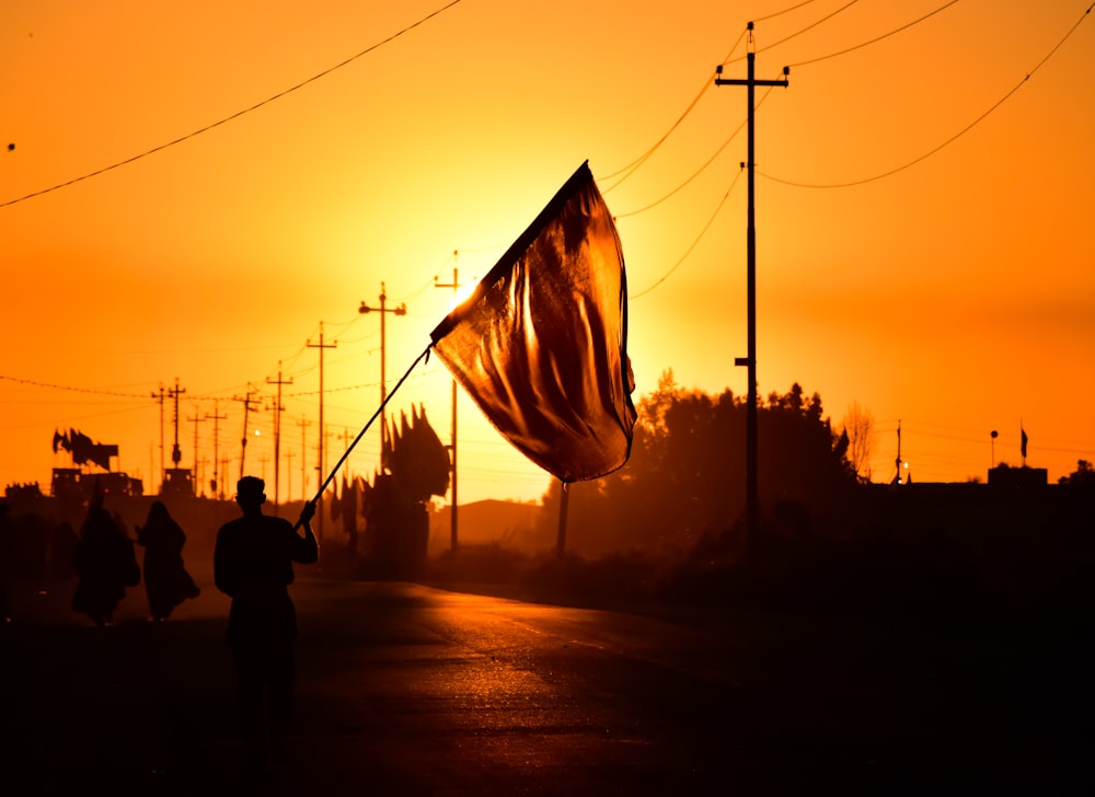 Silueta de la gente que camina por la calle durante la puesta del sol