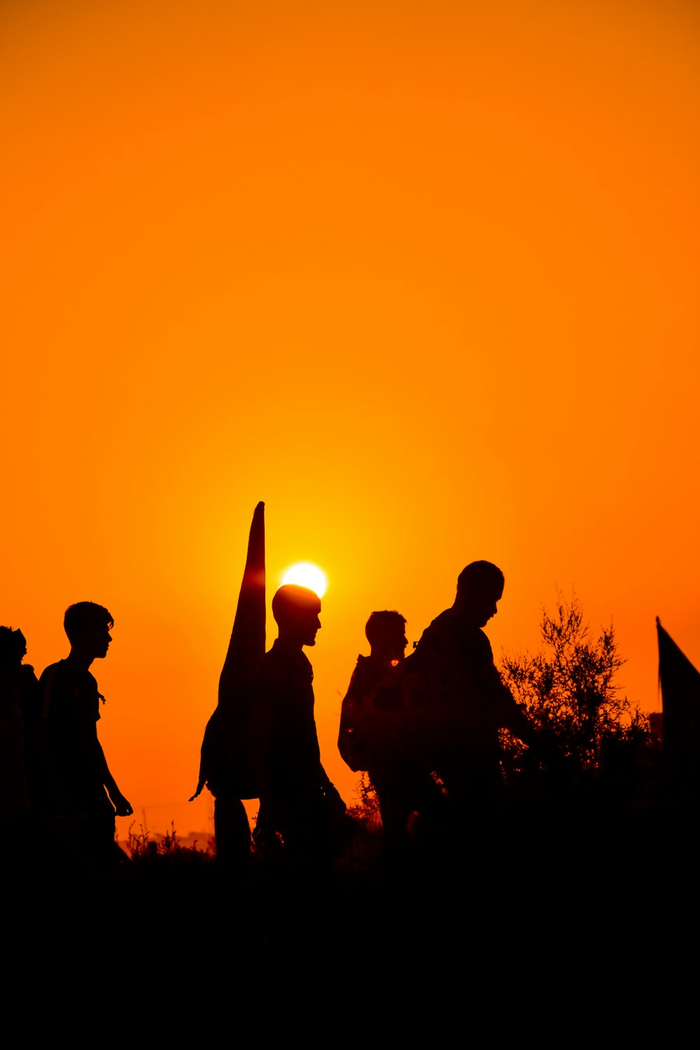 Silueta de personas de pie durante la puesta del sol