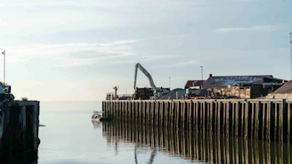 Project managers reviewing blueprints near a dock.