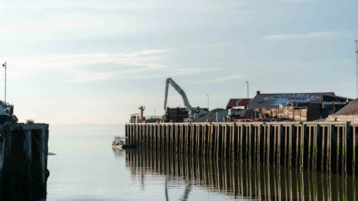 Project managers reviewing blueprints near a dock.