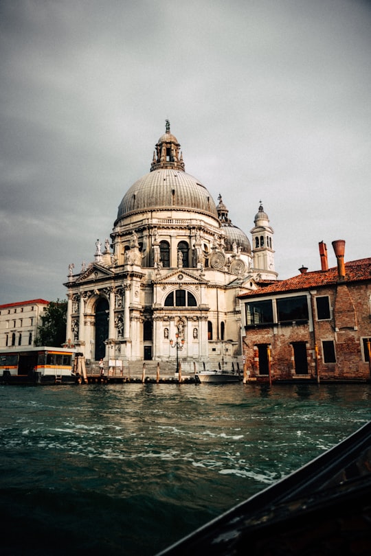 white and brown dome building near body of water during daytime in Santa Maria della Salute Italy