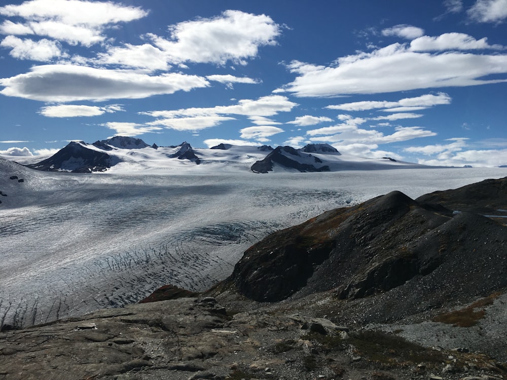 brown and green mountain under white clouds and blue sky during daytime