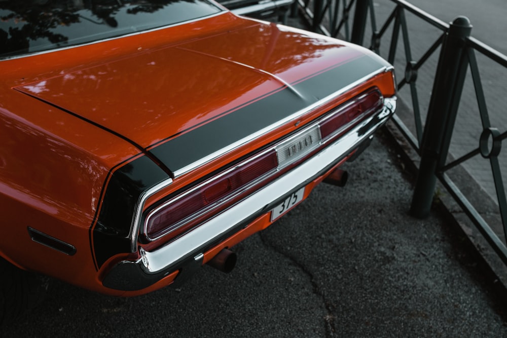 orange car on gray asphalt road during daytime