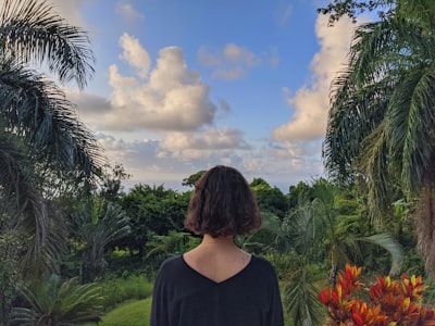 woman in black shirt standing near green grass field under blue and white cloudy sky during dominican republic zoom background