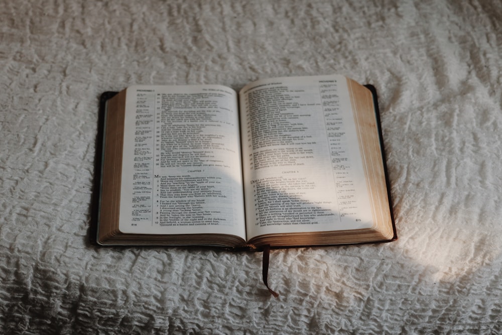 opened book on white textile