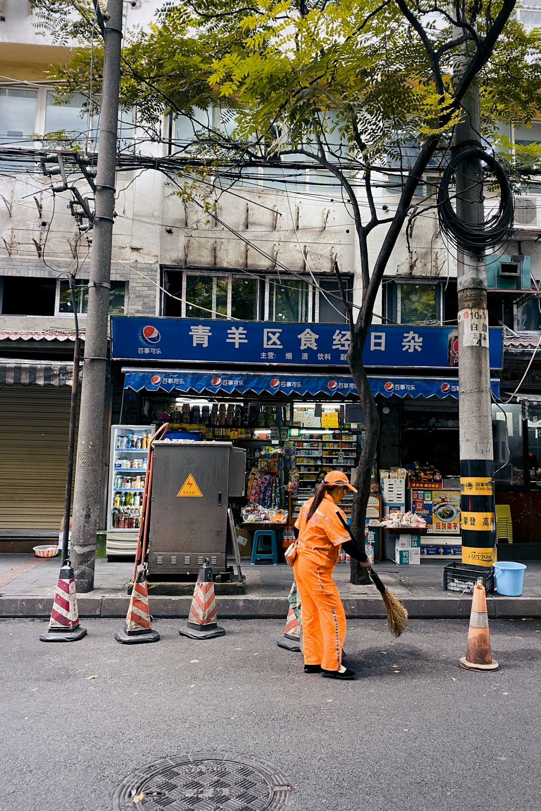 man in orange jacket and brown pants walking on sidewalk during daytime
