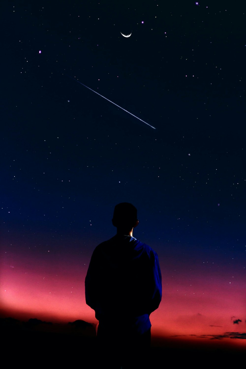 Hombre con camisa azul de pie bajo la noche estrellada
