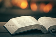 An open book on a wooden table with soft lighting.