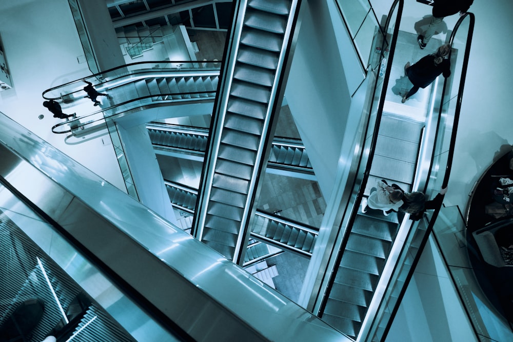 Personas caminando por las escaleras mecánicas dentro del edificio