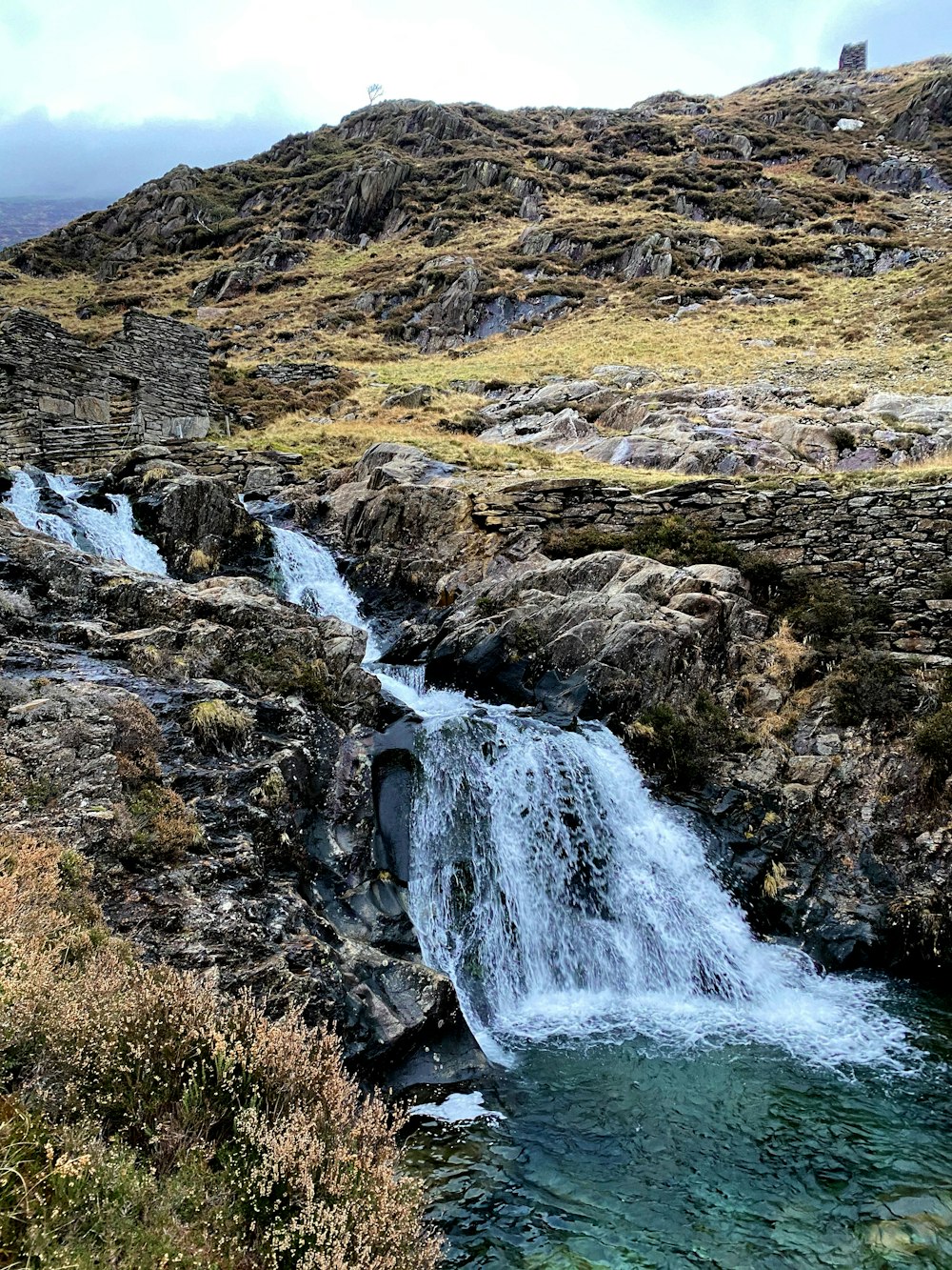 water falls on brown and green grass field during daytime