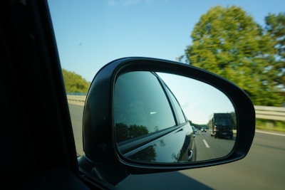 A driver checking mirrors before changing lanes on a highway.