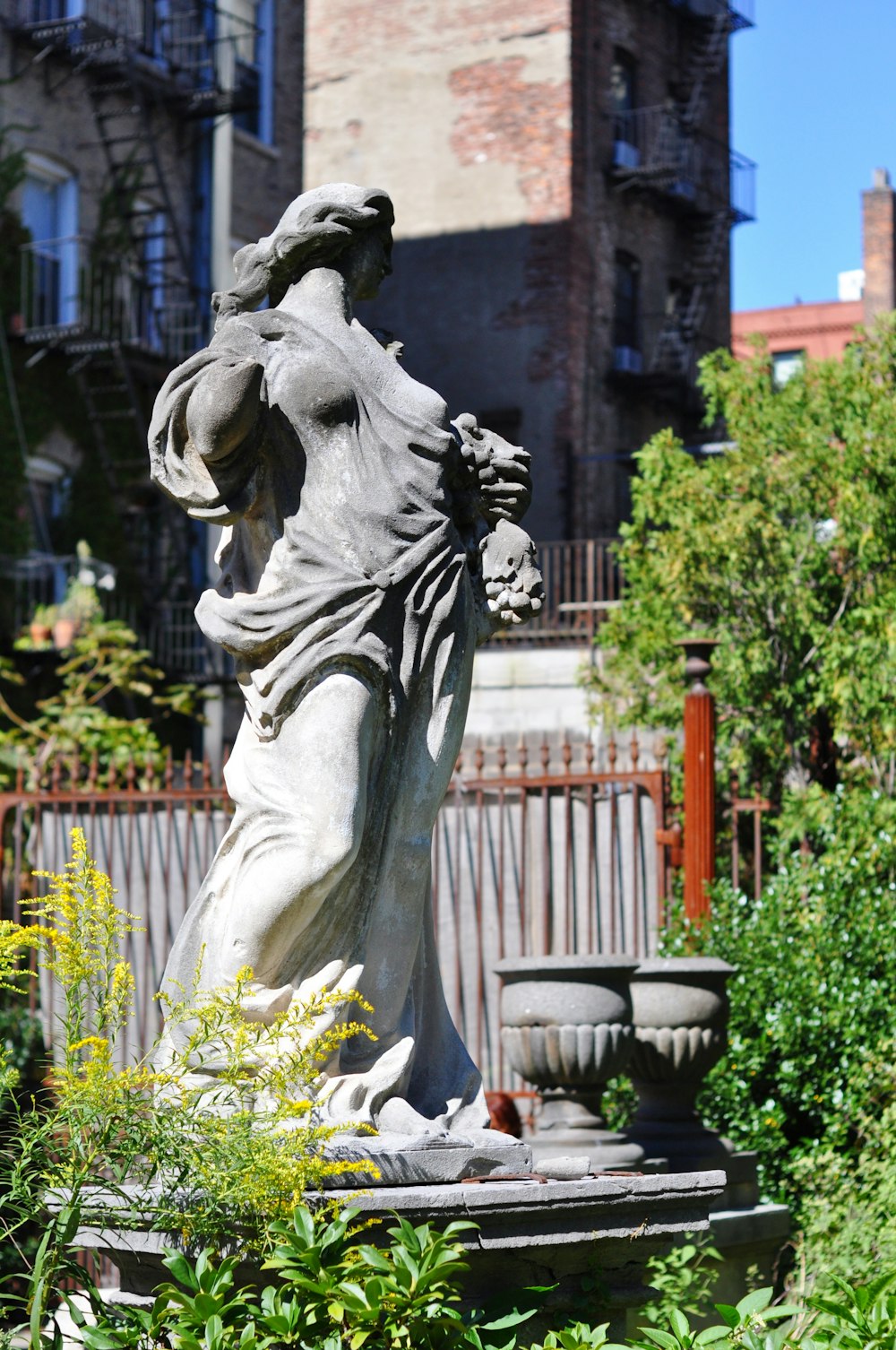 statue of man holding book