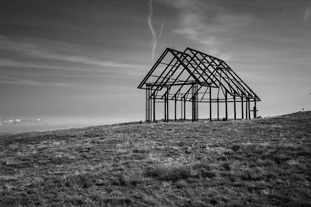 Foto en escala de grises de un marco de metal en un campo