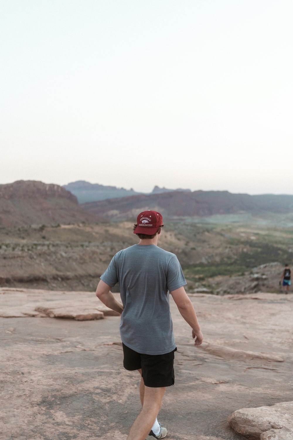 man in gray crew neck t-shirt standing on brown sand during daytime