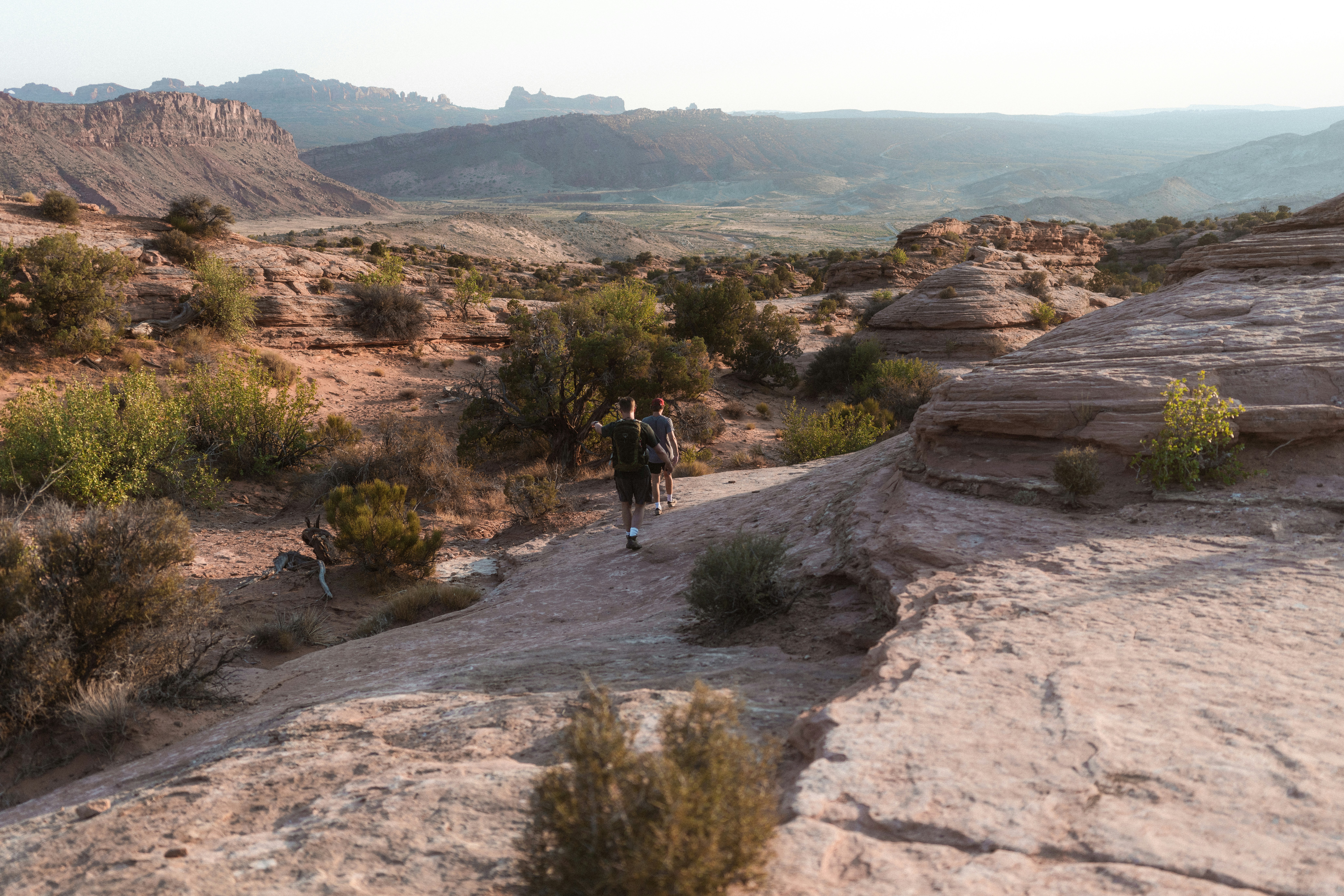 man in black jacket walking on brown rocky mountain during daytime