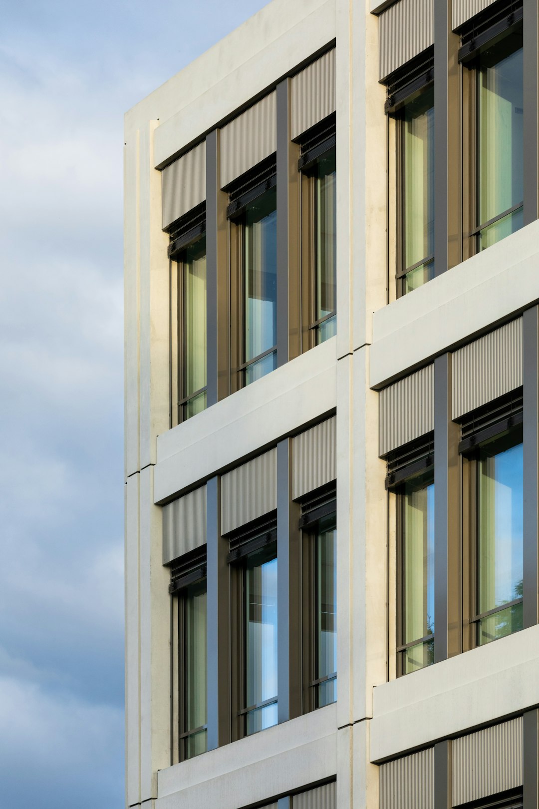 white concrete building under white clouds during daytime