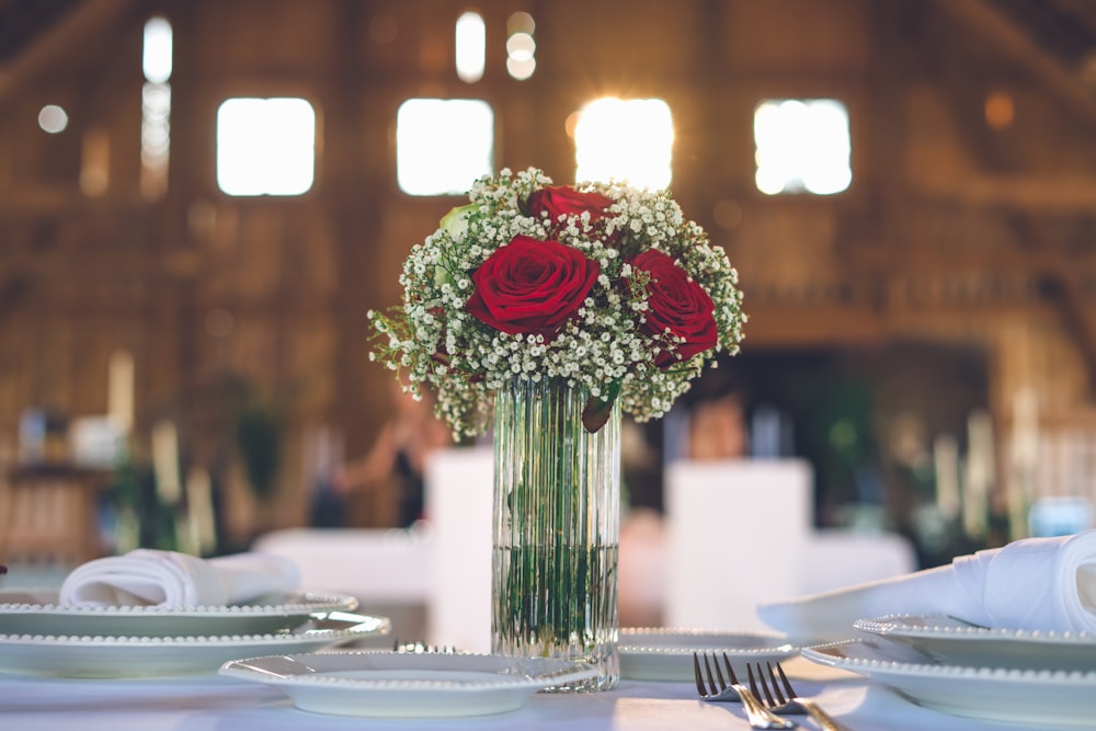 red roses in clear glass vase on table