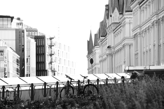 grayscale photo of bicycle parked on sidewalk near building in Oslo Norway