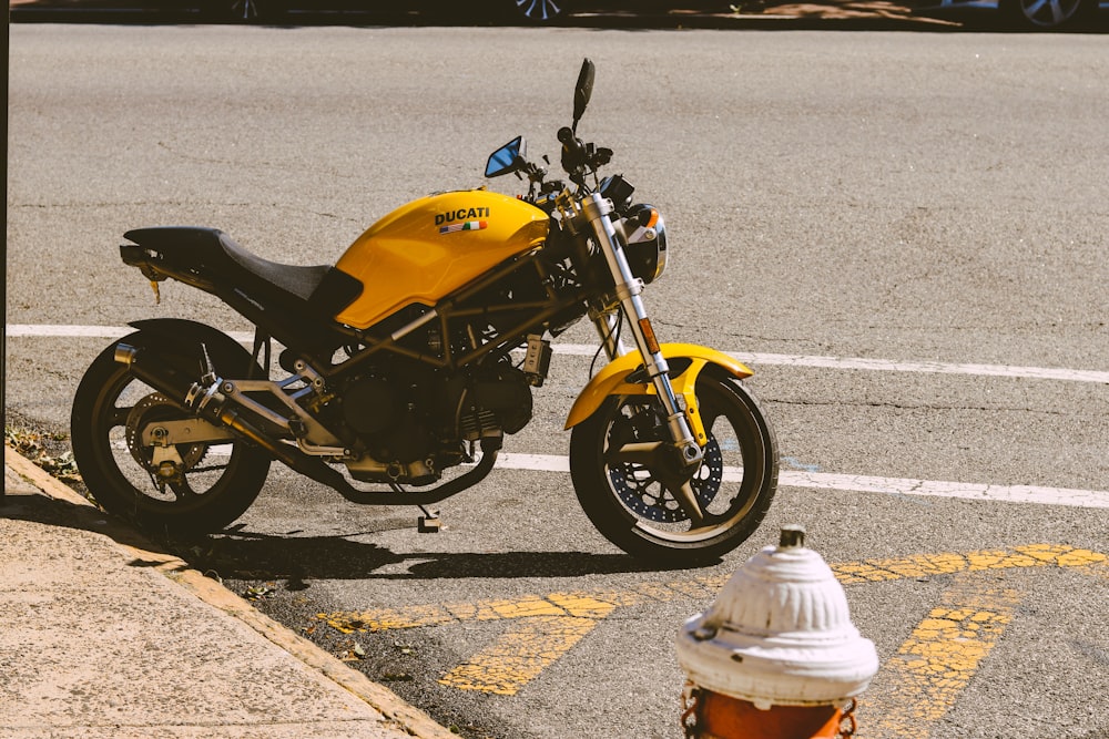 낮 동안 회색 콘크리트 도로에 주차 된 노란색과 검은 색 스포츠 자전거