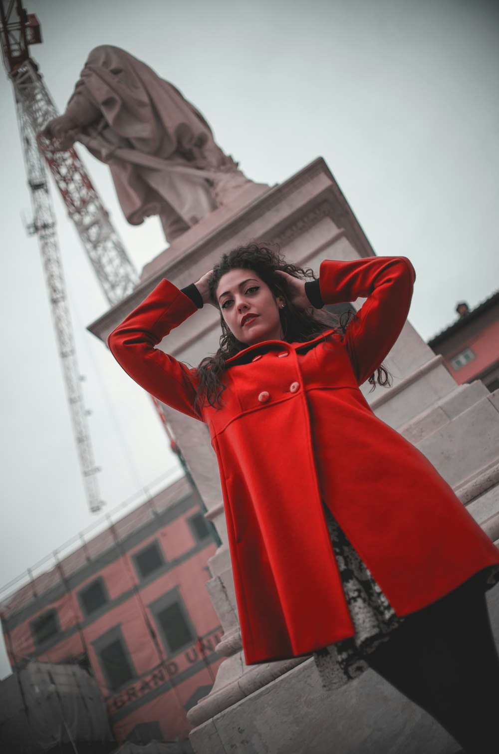 woman in red coat standing near building