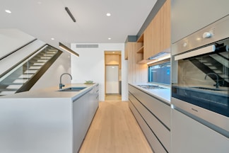brown wooden parquet floor and white wooden kitchen cabinet