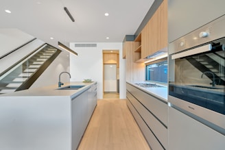 brown wooden parquet floor and white wooden kitchen cabinet